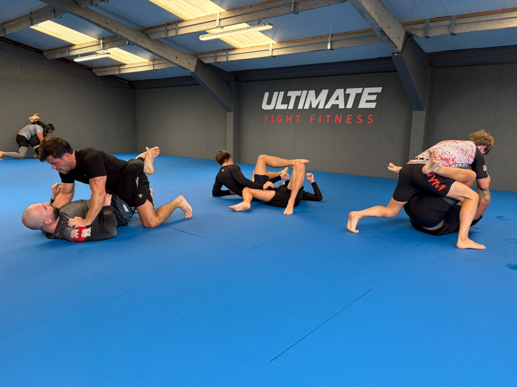 Brazilian Jiu-Jitsu class training on the blue mats at Ultimate Fight Fitness